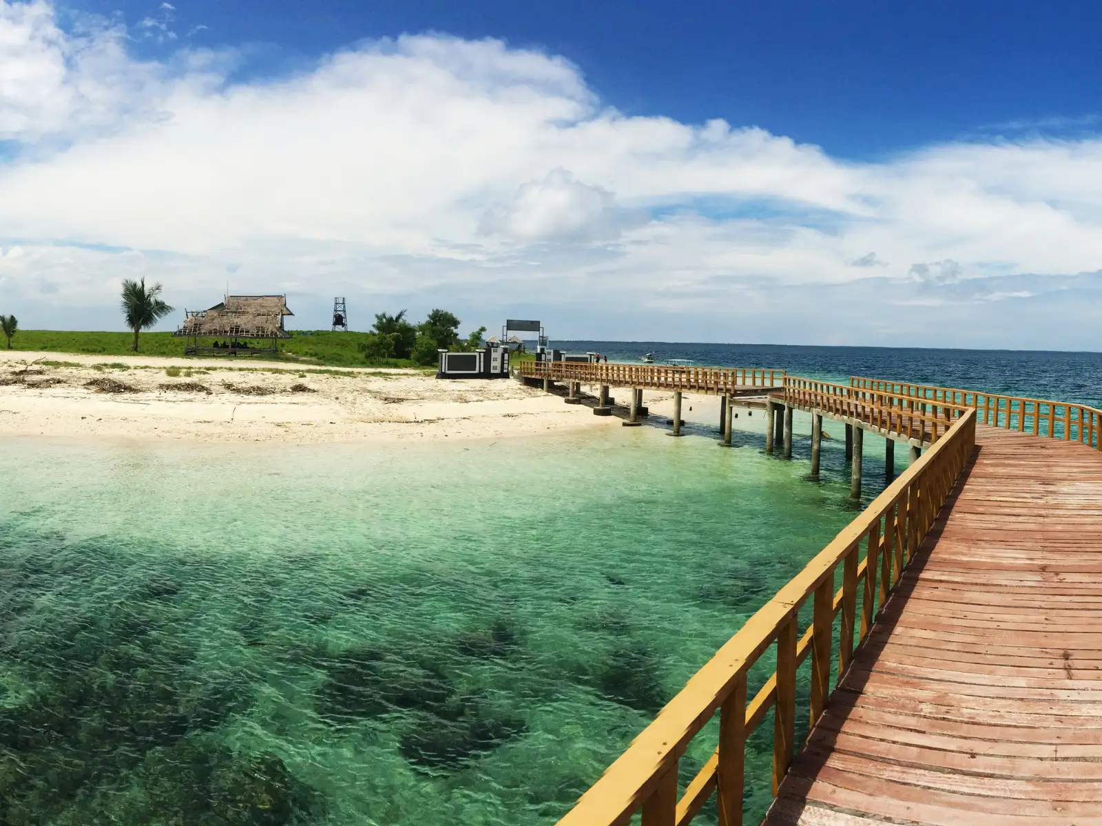 Kenawa Island with calm turquoise water and a green hill