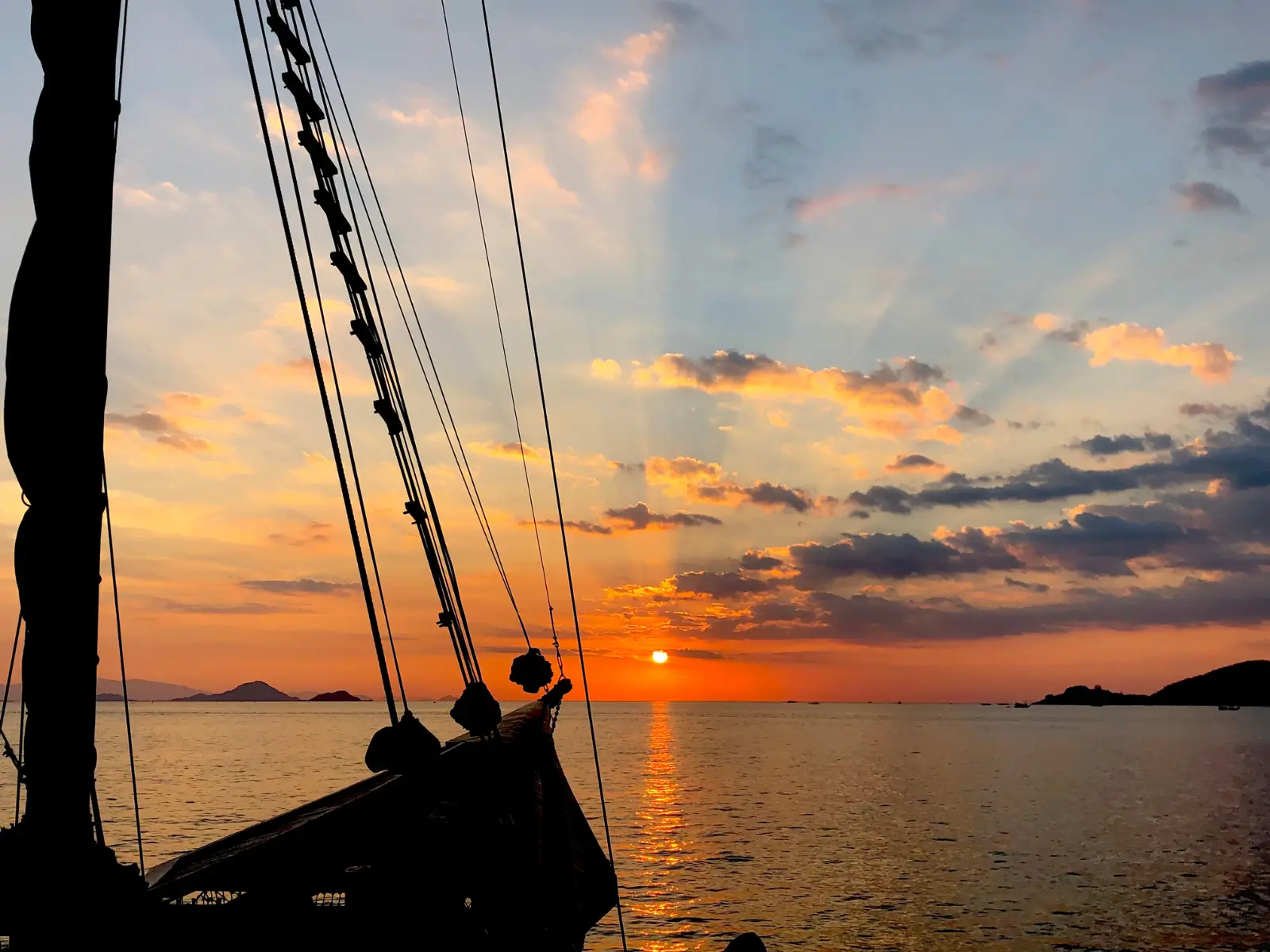 Wooden boat sailing at sunset off Labuan Bajo